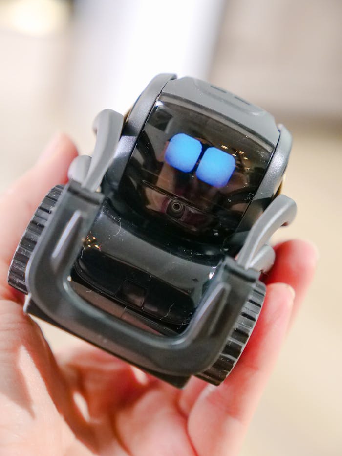 A close-up view of a futuristic miniature robot toy held in hand, showcasing modern technology.
